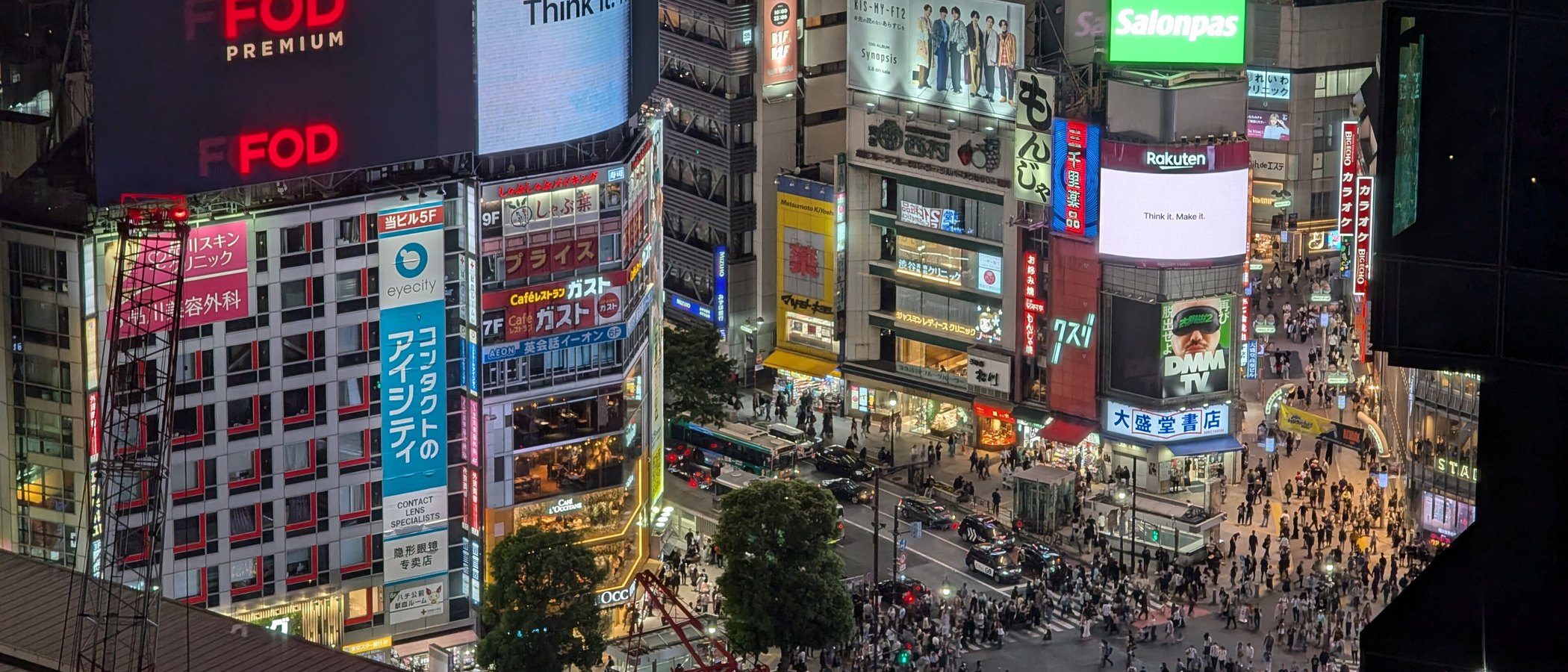 Illuminated retail billboards and shoppers at Shibuya crossing in Tokyo at night